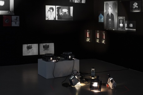 Daniela Friebel|Projektion, 2018|33 Pigmentdrucke, 43 Dias, schwarze Wandverkleidung, 9 Pentacon Projektoren (div. Modelle)